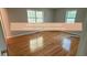 Bright bedroom featuring gleaming hardwood floors and natural light from two windows at 4191 Alaina Circle Cir, Austell, GA 30106