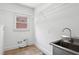 Laundry room with stainless steel sink, tile floor, and shelving at 5059 Belair Bluff Se Ct, Smyrna, GA 30126