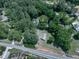 An aerial view showcases the home's serene setting surrounded by a canopy of mature, lush trees and a long driveway at 543 S Holly Springs Rd, Woodstock, GA 30188