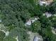 An aerial view showcases the home's serene setting surrounded by a canopy of mature, lush trees and a long driveway at 543 S Holly Springs Rd, Woodstock, GA 30188