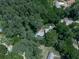 An aerial view showcases the home's serene setting surrounded by a canopy of mature, lush trees and a long driveway at 543 S Holly Springs Rd, Woodstock, GA 30188