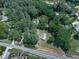 An aerial view showcases the home's serene setting surrounded by a canopy of mature, lush trees and a long driveway at 543 S Holly Springs Rd, Woodstock, GA 30188