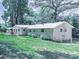 Lush green backyard featuring mature trees, patio with dining set, and tidy landscaping at 543 S Holly Springs Rd, Woodstock, GA 30188