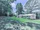 Expansive backyard showcasing a well-maintained lawn, mature trees, patio, and a fenced area at 543 S Holly Springs Rd, Woodstock, GA 30188