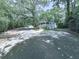 Exterior of home with long driveway, mature trees, screened in porch and detached garage at 543 S Holly Springs Rd, Woodstock, GA 30188