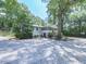 Charming home surrounded by mature trees, features a screened porch and a gravel driveway at 543 S Holly Springs Rd, Woodstock, GA 30188