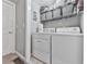 Functional laundry room with washer, dryer, and shelving for convenient storage at 543 S Holly Springs Rd, Woodstock, GA 30188