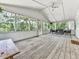 Large screened porch with wood floors, ceiling fan, and outdoor seating at 543 S Holly Springs Rd, Woodstock, GA 30188