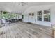 Inviting screened-in sunroom with wood flooring, ceiling fan, and comfortable seating area, perfect for relaxation at 543 S Holly Springs Rd, Woodstock, GA 30188