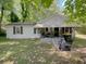 Charming single-story home with a covered porch, surrounded by mature trees and a green lawn at 6385 Highway 92, Fairburn, GA 30213