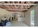 Unfinished living room featuring exposed beams, a door leading to the outside, and neutral colored walls at 6385 Highway 92, Fairburn, GA 30213
