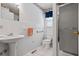 Bathroom with a pedestal sink, toilet, and a glass-enclosed shower at 954 Bryant Sw St, Conyers, GA 30012