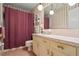 Cozy bathroom featuring a vanity, toilet, and pink tiling with a shower behind a pink curtain at 954 Bryant Sw St, Conyers, GA 30012