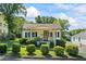 Charming home featuring mature landscaping, a cozy front porch, and a well-maintained lawn on a sunny day at 954 Bryant Sw St, Conyers, GA 30012