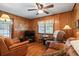 Cozy living room with wood paneling, comfortable seating, and natural light at 954 Bryant Sw St, Conyers, GA 30012