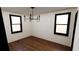 Bright bedroom featuring hardwood floors and natural light from two windows at 1658 Altadena Sw Pl, Atlanta, GA 30311