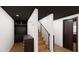 Stairwell features warm wood steps, black metal railing, with access to closet and door at 1658 Altadena Sw Pl, Atlanta, GA 30311