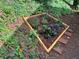 Landscaped garden bed with wooden trim, ready for planting, surrounded by lush greenery at 185 Colemans Bluff Dr, Woodstock, GA 30188