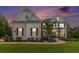 Charming two-story home with a welcoming front porch and beautifully landscaped front yard at twilight at 1865 Henley Way, Alpharetta, GA 30009