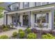 Inviting covered porch with decorative wreaths, stylish seating, and lush landscaping at 1865 Henley Way, Alpharetta, GA 30009