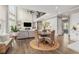 Open-concept living area with a large window, fireplace, and dining area with wicker chairs at 1865 Henley Way, Alpharetta, GA 30009