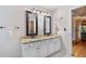 Bright bathroom featuring a double sink vanity with granite countertops and black framed mirrors at 5355 Wyntree Ct, Peachtree Corners, GA 30071