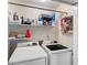 Functional laundry room equipped with modern washer and dryer units and ample shelving at 5355 Wyntree Ct, Peachtree Corners, GA 30071