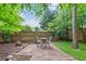 Charming patio area with outdoor seating, surrounded by mature trees and a privacy fence, offering a tranquil retreat at 5355 Wyntree Ct, Peachtree Corners, GA 30071