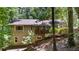 Back exterior view with a wooden deck, and a sloping landscaped yard at 7875 Robin Rd, Cumming, GA 30041