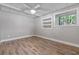 Bedroom with hardwood floors, ceiling fan, and large window with backyard view at 7875 Robin Rd, Cumming, GA 30041