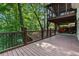 Spacious wooden deck with metal railing, a golf cart underneath, and wooded backyard at 7875 Robin Rd, Cumming, GA 30041