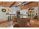 Dining area showcasing wood floors, stone fireplace, access to the kitchen and screened porch at 7875 Robin Rd, Cumming, GA 30041