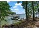 Lake view featuring private covered boat dock and waterfront landscape at 7875 Robin Rd, Cumming, GA 30041