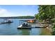 View of boat dock with boat lift and boat house, situated on a serene, picturesque lake at 7875 Robin Rd, Cumming, GA 30041