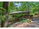 Exterior view of the home nestled among trees, featuring a porch and natural landscaping at 7875 Robin Rd, Cumming, GA 30041