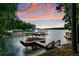 Picturesque lake view with a boat dock and beautiful sunset sky at 7875 Robin Rd, Cumming, GA 30041