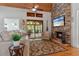 Charming living room with a stone fireplace, hardwood floors, and a view of the screened-in porch at 7875 Robin Rd, Cumming, GA 30041