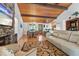 Open-concept living room with stone fireplace, wood ceiling, hardwood floors, and a spacious dining area at 7875 Robin Rd, Cumming, GA 30041