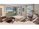 Cozy living room features a brown leather sofa, patterned curtains, and built-in shelving at 7875 Robin Rd, Cumming, GA 30041