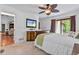 Well-lit main bedroom with a ceiling fan, mounted television, and a sliding door to a private balcony at 7875 Robin Rd, Cumming, GA 30041