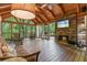 Inviting screened porch featuring a stone fireplace, comfortable seating, and wooded views at 7875 Robin Rd, Cumming, GA 30041
