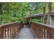 Wooden walkway leading to the charming home, surrounded by lush greenery at 7875 Robin Rd, Cumming, GA 30041
