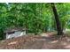 View of a small outbuilding and lake access path with lush greenery and mature trees at 7875 Robin Rd, Cumming, GA 30041