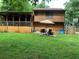 Exterior view of a home with a screened porch, wooden siding, a patio set, and a well-maintained lawn at 170 Beatrice St, Dallas, GA 30157