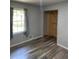 Bedroom with grey painted walls, window with curtains, and wood-look flooring at 170 Beatrice St, Dallas, GA 30157
