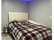 Bedroom with plaid bedspread, side table, and a neutral color scheme at 170 Beatrice St, Dallas, GA 30157