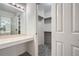 Bright bathroom vanity with mirror, storage, and walk-in closet featuring ample shelving at 2901 Lenox Rd # 702, Atlanta, GA 30324