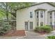 A townhome showing its siding and front entryway with a garden and trees surrounding the property at 2901 Lenox Rd # 702, Atlanta, GA 30324