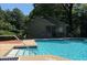 Community pool with lifeguard station, deck furniture, and clear blue water at 2901 Lenox Rd # 702, Atlanta, GA 30324