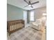 Neutral bedroom with a ceiling fan, crib, and white armchair at 3816 Harris Nw Blvd, Kennesaw, GA 30144